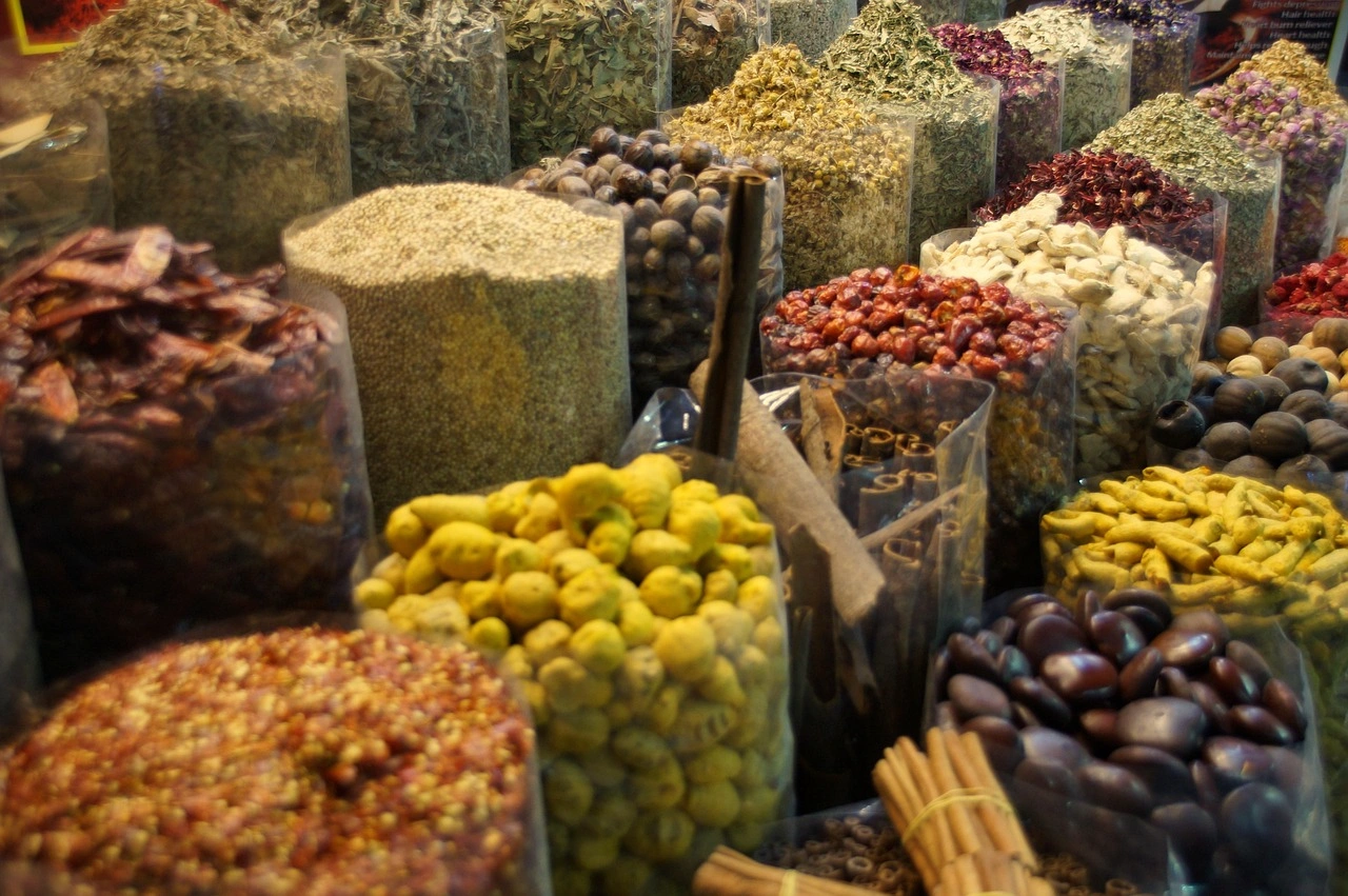 Diversas especiarias e ervas tradicionais expostas em sacos no Souk de Especiarias de Dubai, mostrando cores e texturas típicas do mercado árabe.