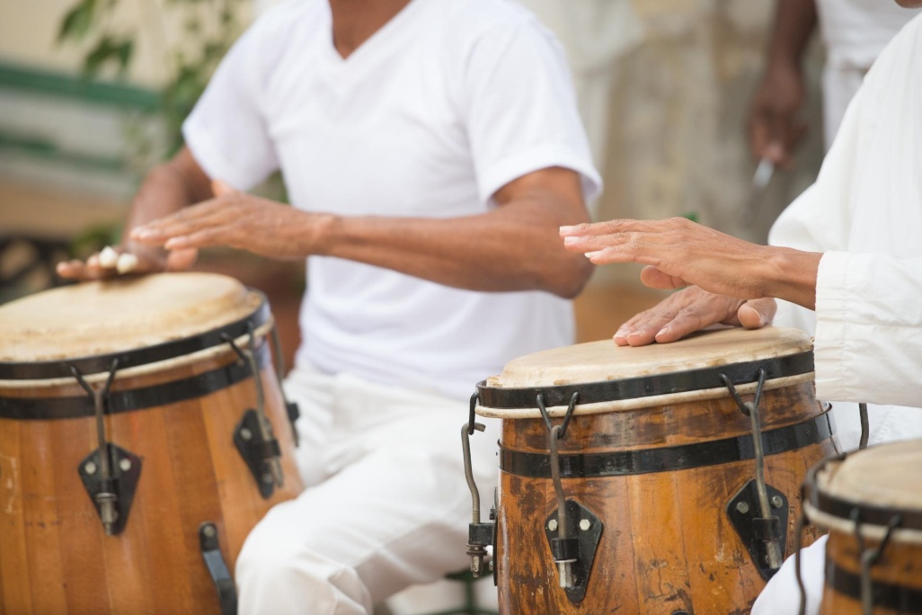 Músicos em Cuba tocando tambores tradicionais de madeira, criando ritmos típicos da música cubana.